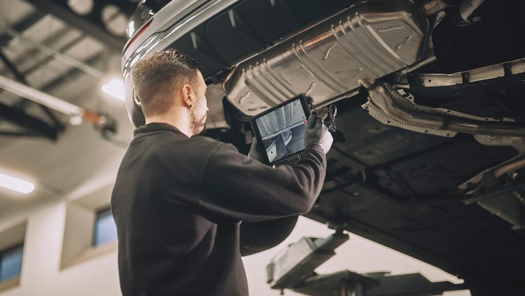 A car technician using the Pinewood system to inspect and record a vehicle