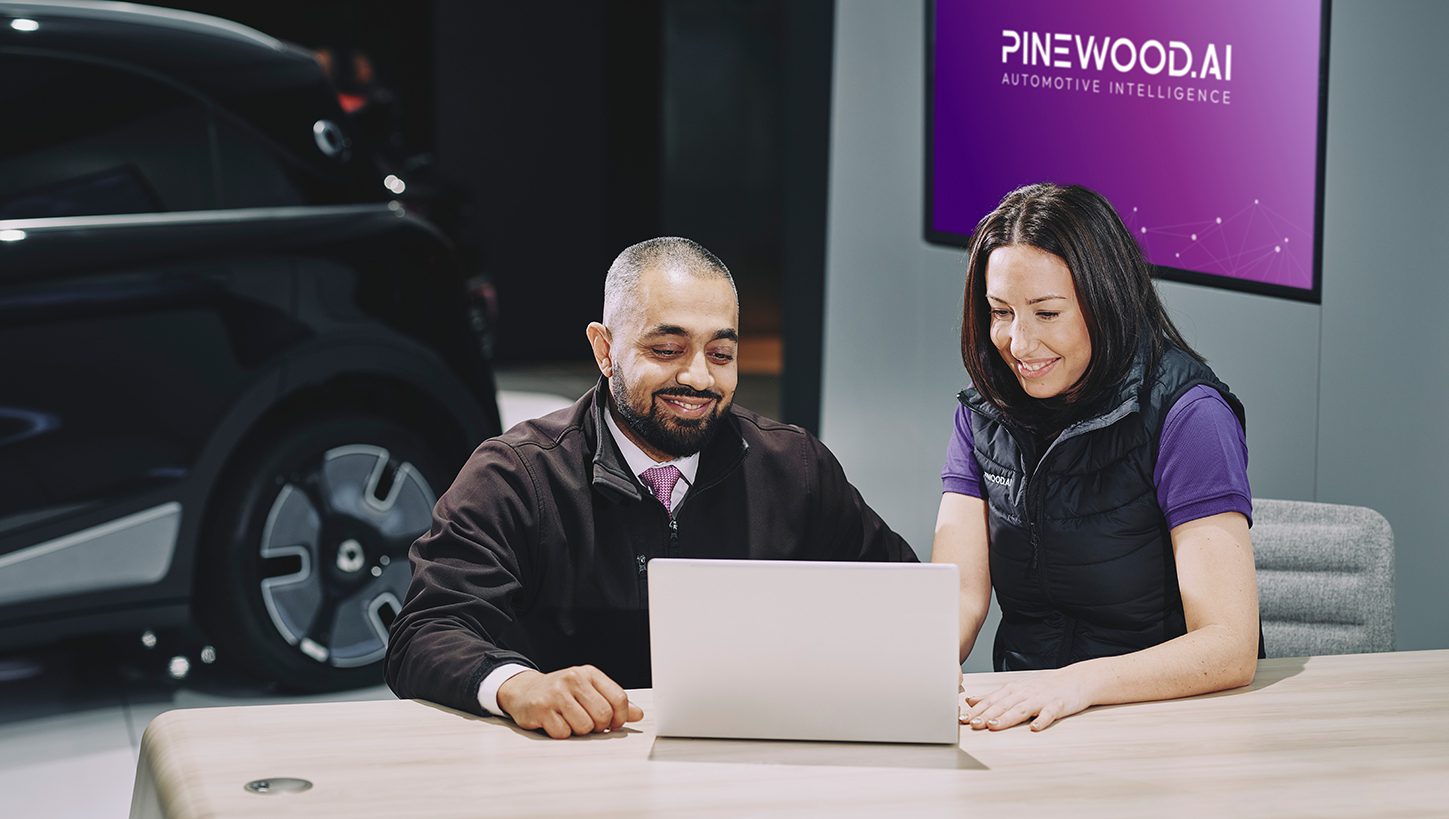 A Pinewood employee showing the someone the Pinewood system